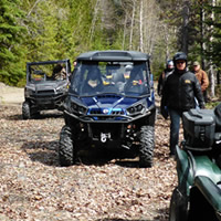 Several ATVs and UTVs parked by a river in Creston, B.C. 