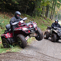 Two ATVers riding on a Forest Service Road. 