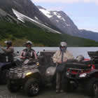 A group of ATVer parked in front of an alpine lake. 