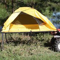 A yellow tent on legs attached to a red ATV. 