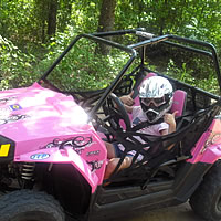 A youth riding a RZR side by side. 