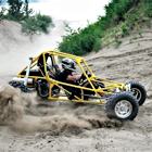 A dune buggy sprays a rooster-tail of sand as it tops out on a lakeside dune