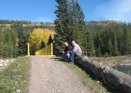 A man and a woman sitting in front of a bridge