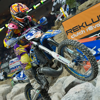 A woman riding a blue bike over rock obstacles. 