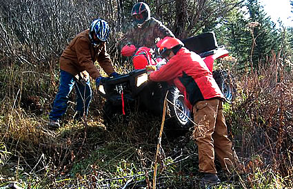 Photo of people pushing an ATV