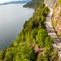 Motorcycles riding along twisty Kootenay Lake road. 