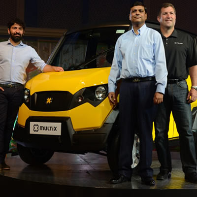 Picture showing 3 men standing in front of the Multix, a yellow and black personal utility vehicle. 