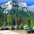 Photo of ATVers in the mountains with their dog