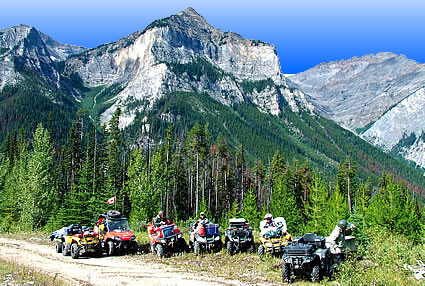 Photo of ATVers in the mountains with their dog