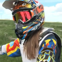 A woman wearing a helmet with long brown hair flowing out of it. 