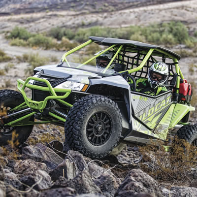 Two men riding in an Arctic Cat Wildcat side by side. 