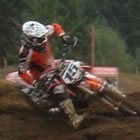 Photo of two riders railing a burm on a motocross track. 