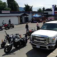 Yamaha truck and trailer parked at dealership with motorcycles all around. 